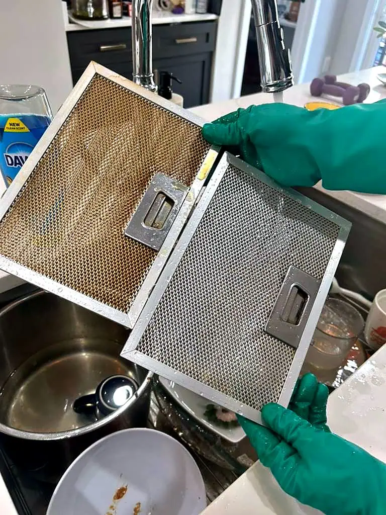 Two range-hood filters held side by side, one greasy and one degreased to bare metal