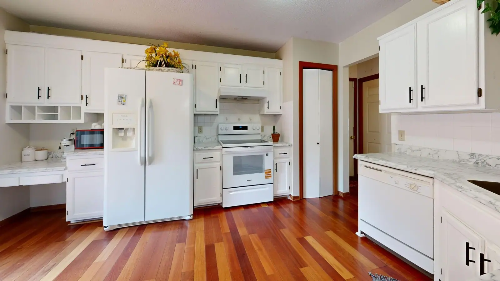 Bright kitchen with white cabinets and hardwood floors