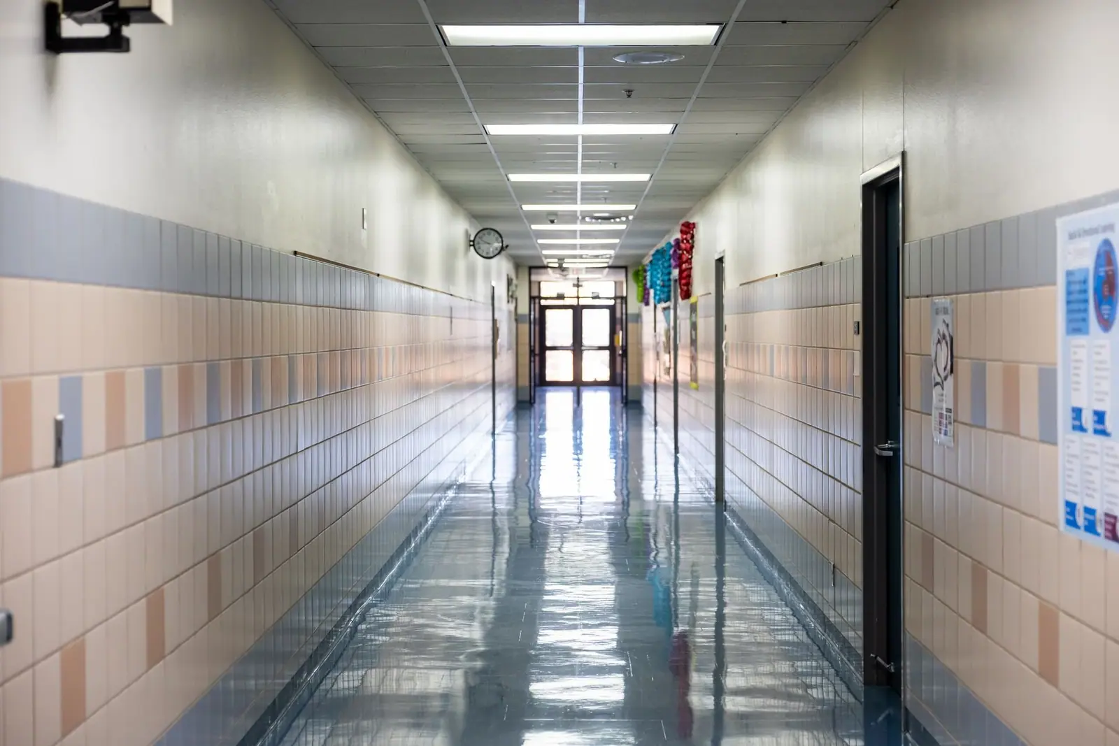 Long school corridor with a high-gloss tile floor
