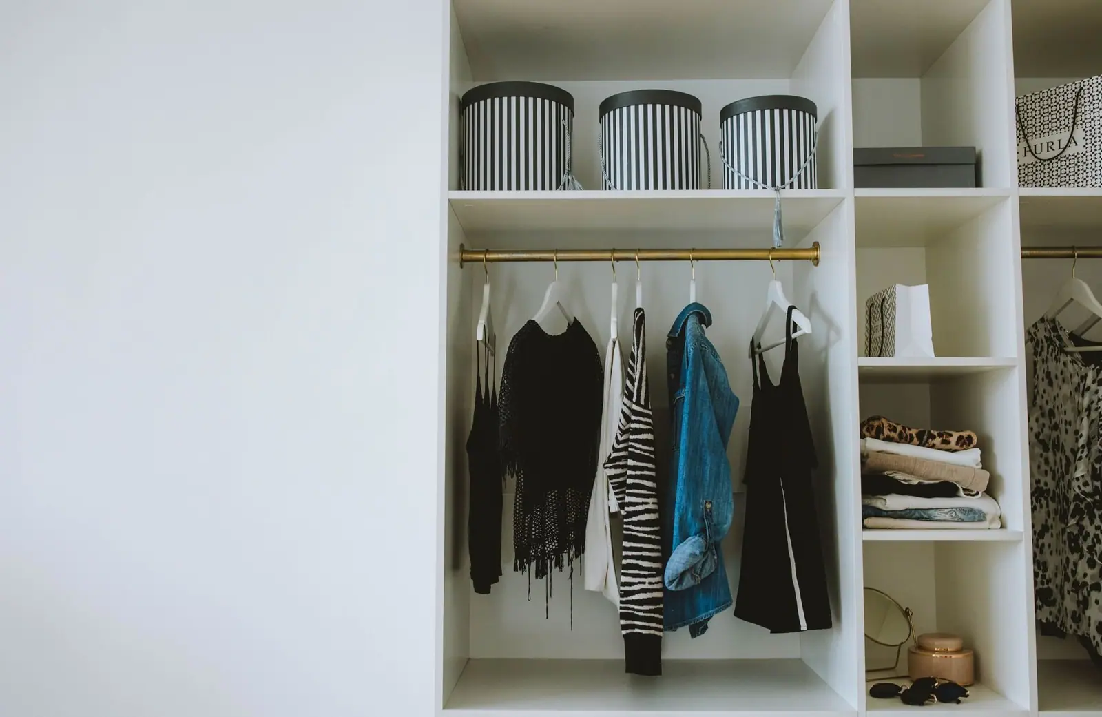 Organized wardrobe with hanging clothes and storage boxes